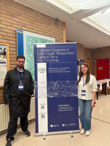 Alejandro Saavedra Mejuto and Sabela Fernández Sánchez pose next to the event's roll-up banner