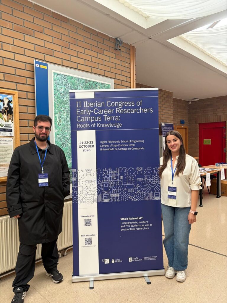 Alejandro Saavedra Mejuto and Sabela Fernández Sánchez pose next to the event's roll-up banner